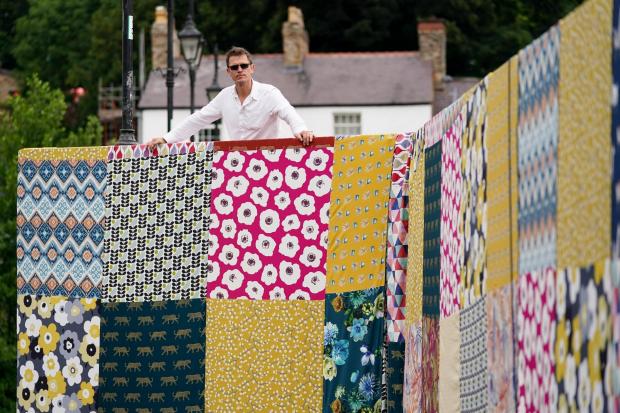 Artist Luke Jerram at the unveiling of his new artwork 'Bridges, Not Walls', a giant patchwork covering the Llangollen Bridge in north Wales, for the launch the Llangollen Eisteddfod.