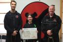 Lucy Ranales-Griffiths with her black belt certificate