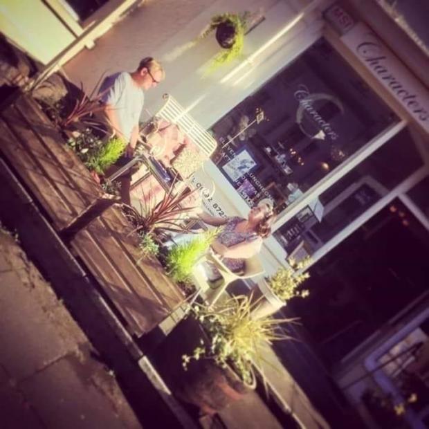 North Wales Pioneer: An old photo of Annie and Brett sat outside Characters after a busy day. Photo: Chloe Jackson