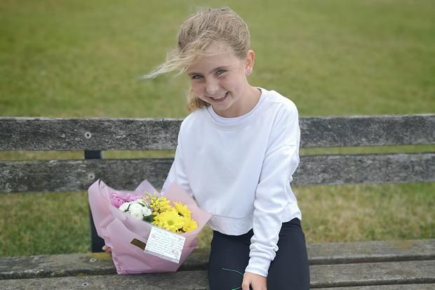 Elsbeth's daughter, Jessica places a bouquet on a bench in Buckley Common to celebrate National Lonely Bouquet day. Photo provided by Elsbeth  Cleary.