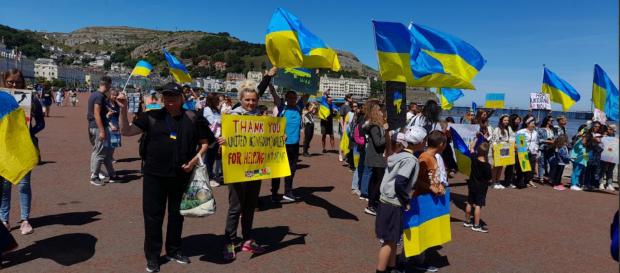 North Wales Pioneer: Ukrainian flags waved at the peace march. Photo: Helen Denning