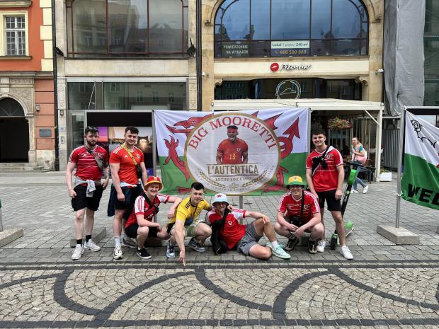 North Wales Pioneer: Wales superfan Cai Jones and friends with their popular 'Big Mooretti' flag. Photo: Cai Jones
