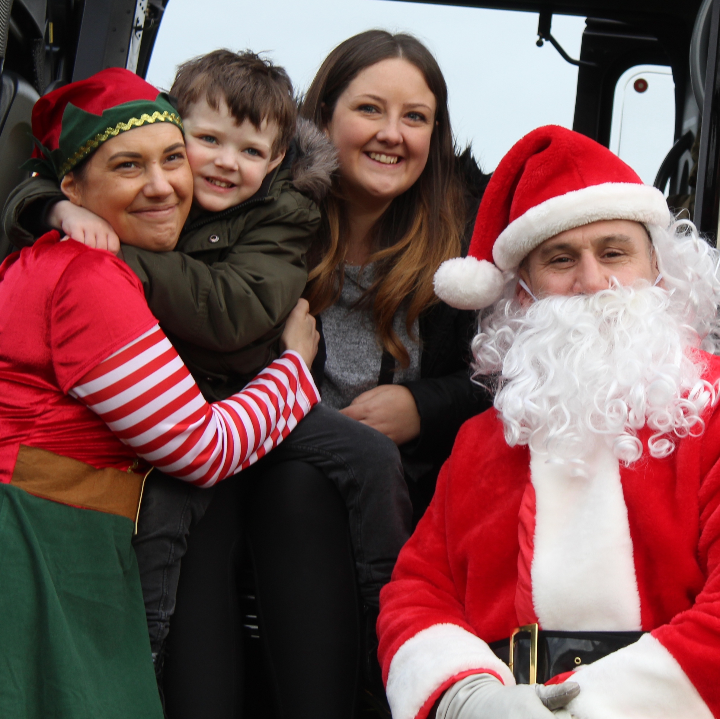 Elf Jenny with Henry and his mum and Santa in the helicopter.