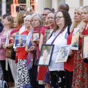 People hold pictures of loved ones lost during the pandemic outside the UK Covid-19 Inquiry at Dorland House in London. Picture: PA