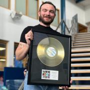 Past student Krystian Kozi?ski with the gold disc presented to him at Coleg Llandrillo.
